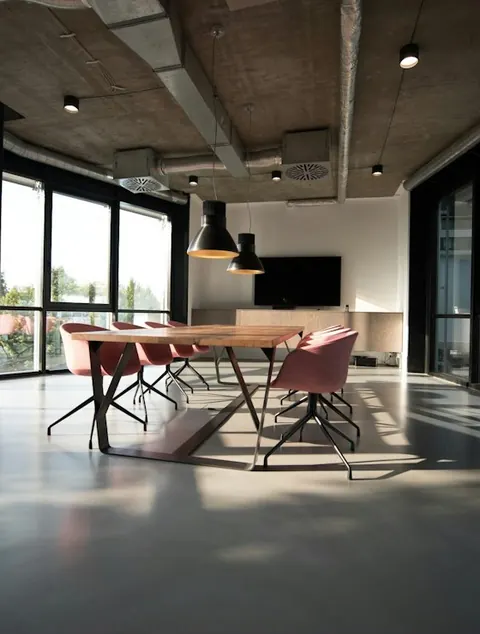 Sala de reuniões com mesa de madeira e cadeiras